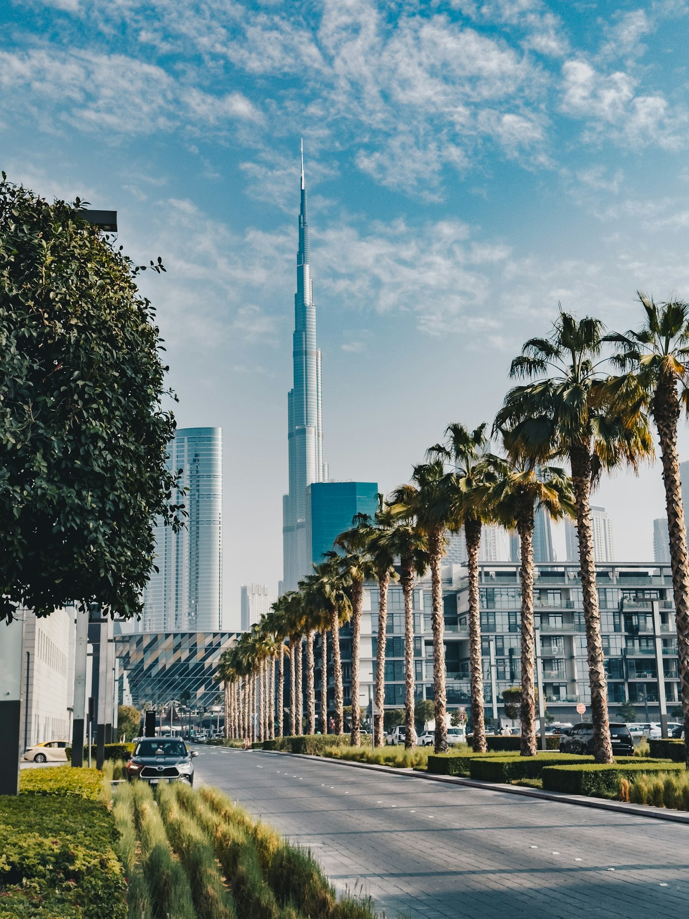 A palm-lined Downtown Dubai street with Burj Khalifa in the distance