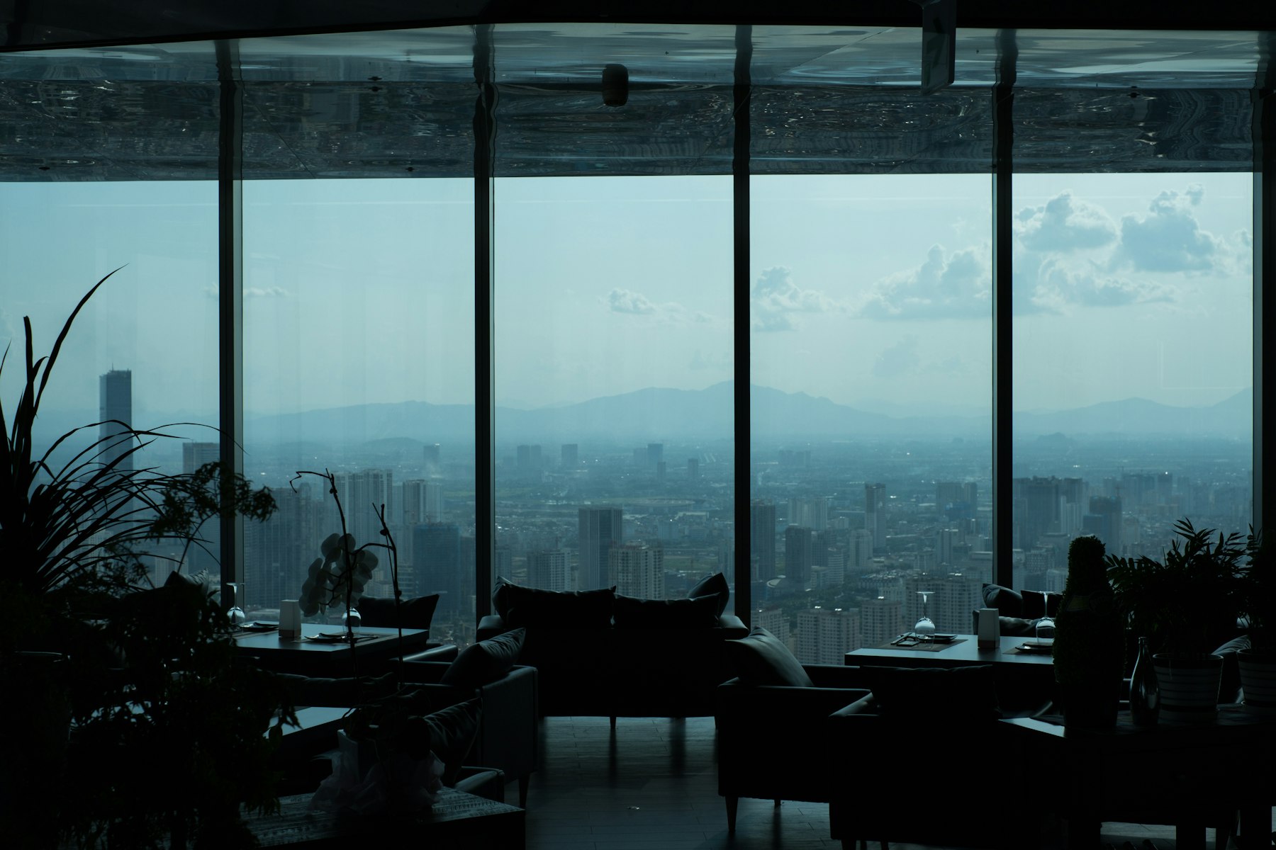 A lounge with floor-to-ceiling windows overlooking a city skyline