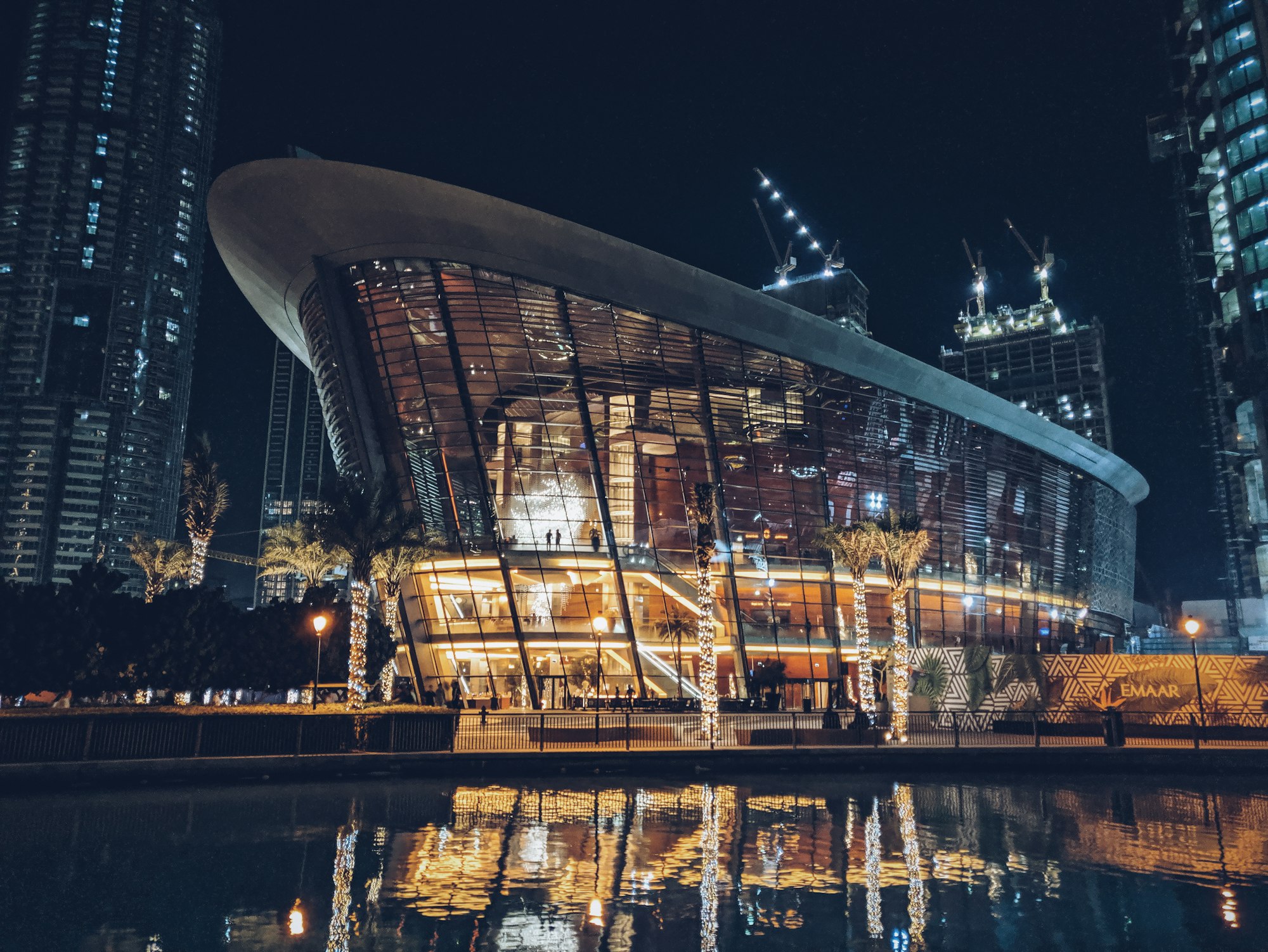 Dubai Opera illuminated at night and reflected in the water